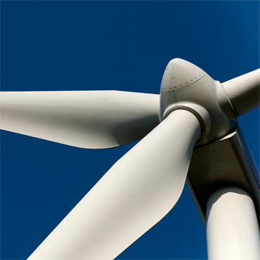 square image of renwable energy wind turbine against blue sky